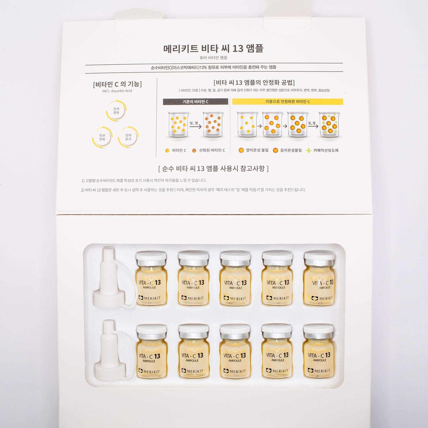 Box of MERIKIT Vita-C 13 Ampoules with ten small glass vials containing vitamin C serum and two applicator droppers on white background